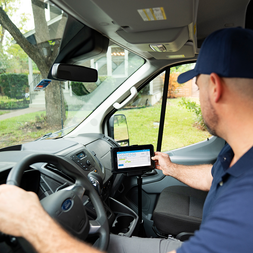A van driver using MyGeotab touch based interface mounted in the van